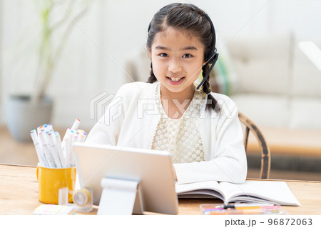 タブレットを見ながら勉強する小学生の女の子 タブレットを見ながら勉強する小学生の女の子 96872063