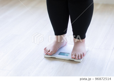 体重計に乗った女性の足元 96872514