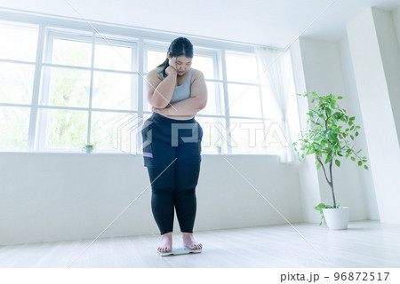 体重計に乗って考える女性 96872517