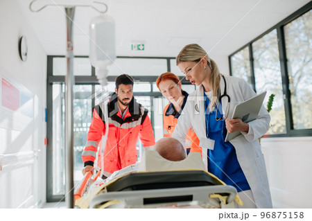 Young woman doctor taking care of patient from rescue ambulance. 96875158