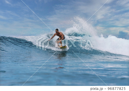 Shirtless male surfer on a wave at sunny day Shirtless male surfer on a wave at sunny day 96877825