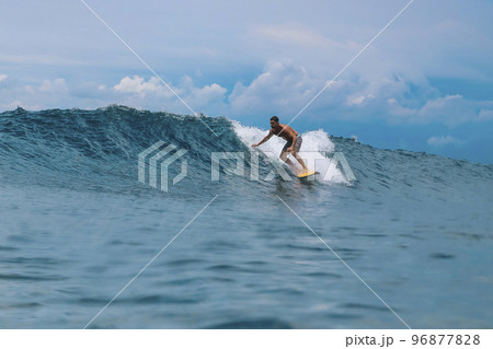Shirtless male surfer on a wave at sunny day 96877828