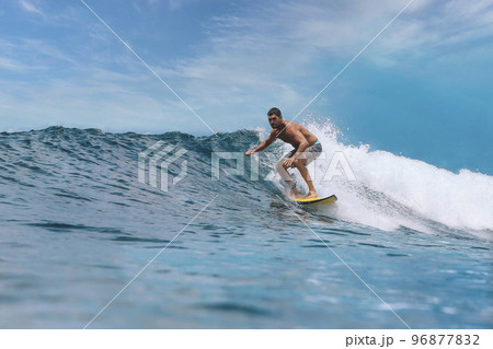 Shirtless male surfer on a wave at sunny day Shirtless male surfer on a wave at sunny day 96877832