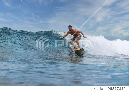 Shirtless male surfer on a wave at sunny day Shirtless male surfer on a wave at sunny day 96877833
