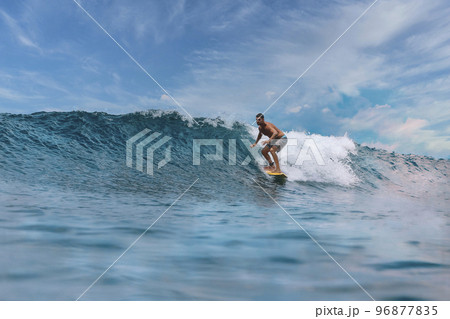 Shirtless male surfer on a wave at sunny day 96877835