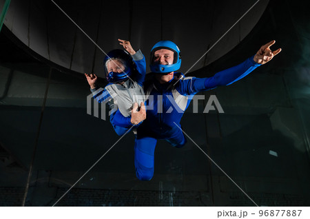 A man teaches a boy to fly in a wind tunnel. Lack of gravity. 96877887