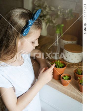 Little girl holding a pot of seedlings 96877984
