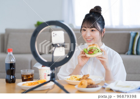 モッパン ハンバーガーを手にライブ配信するユーチューバー モッパン ハンバーガーを手にライブ配信するユーチューバー 96879398