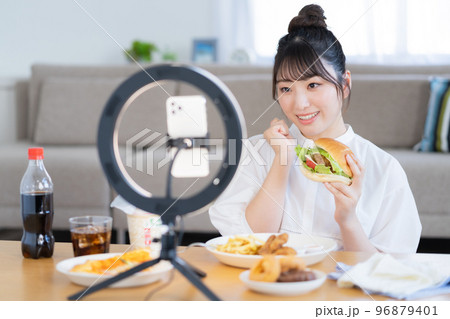モッパン　ハンバーガーを手にライブ配信するユーチューバー 96879401