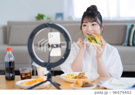 モッパン　ハンバーガーを手にライブ配信するユーチューバー 96879402