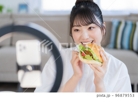 モッパン ハンバーガーを手にライブ配信するユーチューバー モッパン ハンバーガーを手にライブ配信するユーチューバー 96879553
