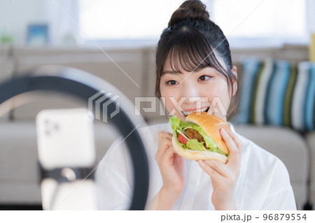 モッパン ハンバーガーを手にライブ配信するユーチューバー モッパン ハンバーガーを手にライブ配信するユーチューバー 96879554