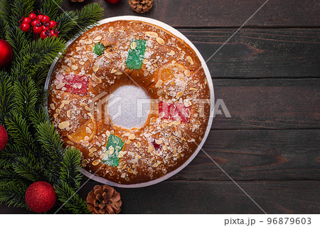Roscon is a traditional Spanish Christmas pastry prepared with dought on the dark background Roscon is a traditional Spanish Christmas pastry prepared with dought on the dark background 96879603