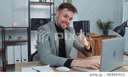 Happy business man looking approvingly at camera showing thumbs up, like positive sign, good news Happy business man looking approvingly at camera showing thumbs up, like positive sign, good news 96880403