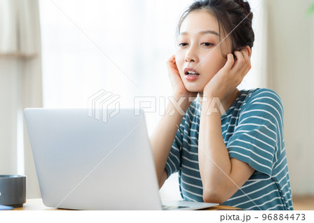 パソコンを見ながら悩む若い女性 パソコンを見ながら悩む若い女性 96884473