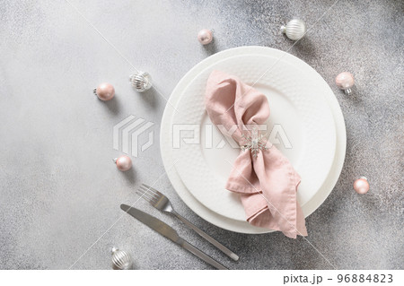 Christmas festive table setting with pink ball and napkin on gray table. Christmas festive table setting with pink ball and napkin on gray table. 96884823