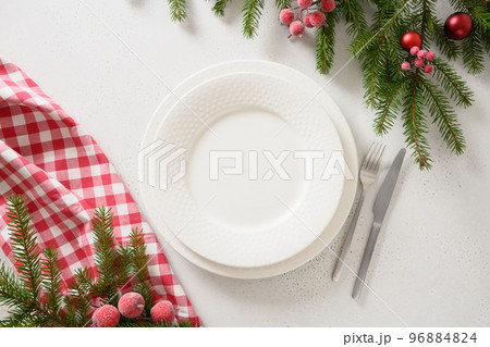 Christmas table setting with elegant red decorations on white table. View from above. Christmas table setting with elegant red decorations on white table. View from above. 96884824