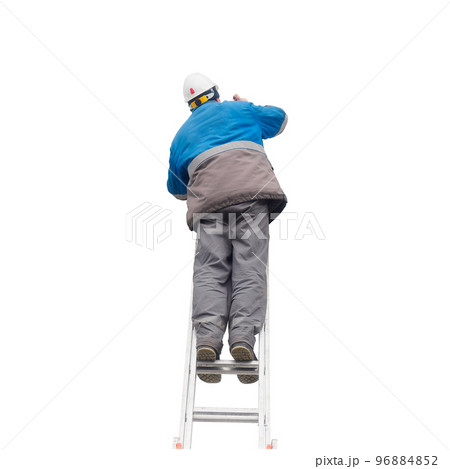 Man in winter work clothes and construction helmet climbs stairs. Male builder on stairs. View from Man in winter work clothes and construction helmet climbs stairs. Male builder on stairs. View from 96884852