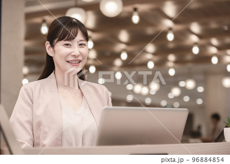 ノートパソコンを持って立つ女性 96884854