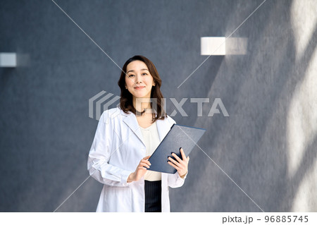 病院でカルテを確認する白衣を着た笑顔の女性医師 病院でカルテを確認する白衣を着た笑顔の女性医師 96885745