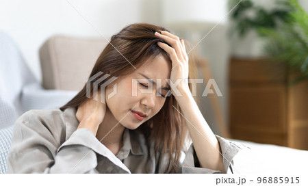 Stressed woman holding her temples with severe problems in her life, Family problems, Pressure from work, Poor financial, Despair in life, discouraged and deeply saddened, Panic attacks. Stressed woman holding her temples with severe problems in her life, Family problems, Pressure from work, Poor financial, Despair in life, discouraged and deeply saddened, Panic attacks. 96885915