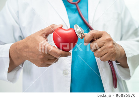 Doctor holding a red heart in hospital ward, healthy strong medical concept. Doctor holding a red heart in hospital ward, healthy strong medical concept. 96885970
