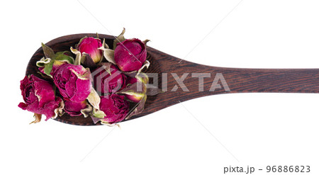 Heap of dry tea roses buds in wooden spoon, isolated on white background. Rose flower tea. Phnom Penh rose tea. Clipping path. Top view. 96886823