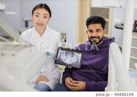 Young asian woman dentist holding tablet pc with x ray scan. Young asian woman dentist holding tablet pc with x ray scan. 96888198