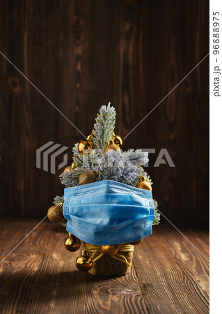 Christmas tree with surgical or medical mask on wooden background 96888975