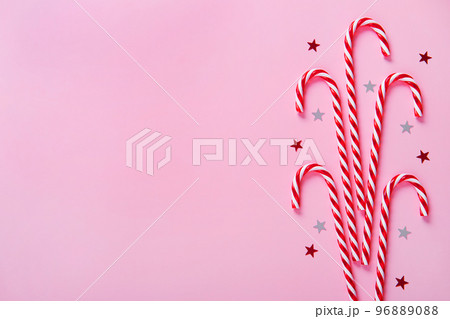 Christmas composition. Candy canes, holiday decorations on a pink background. Christmas composition. Candy canes, holiday decorations on a pink background. 96889088