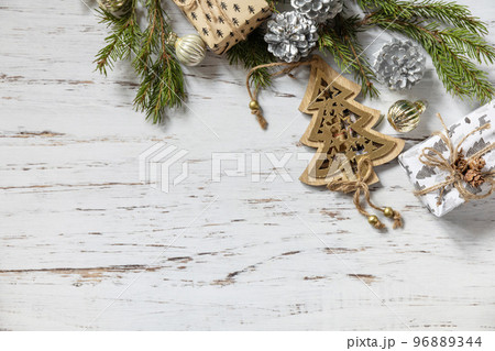 Christmas gold decor, fir tree twigs and gifts box on a white wood background. View from above. Copy space. 96889344