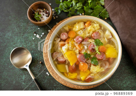 Traditional Zelnacka cabbage soup with sausages and vegetables in a bowl on a stone tabletop. Czech cuisine. Copy space. 96889369