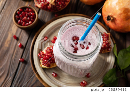 Vegan protein smoothie made from pomegranate and banana on a rustic wooden table. Healthy food, healthy lifestyle. Foodism, raw food diet. 96889411