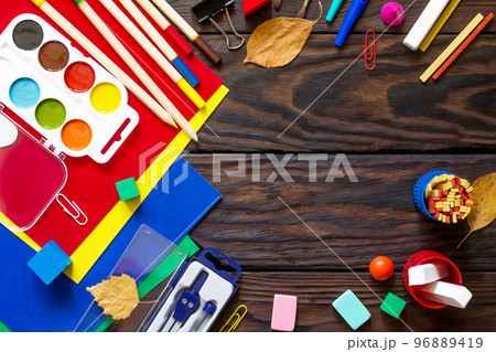 Back to school background with school supplies and autumn leaves on a wooden table. Copy space 96889419
