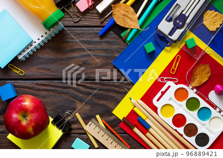 Back to school background with school supplies, autumn leaves and apple on a wooden table. Top view flat lay background, copy space. 96889421