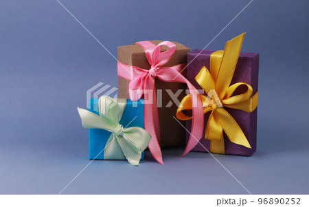 Three multicolored gift boxes on blue background. 96890252