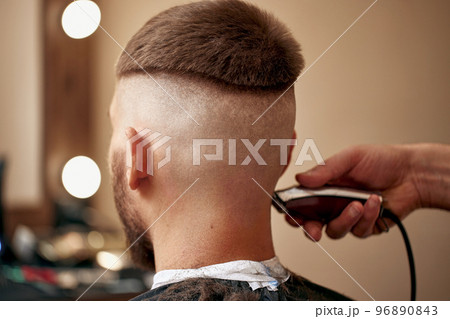 Barber shaving caucasian man in barber shop Barber shaving caucasian man in barber shop 96890843