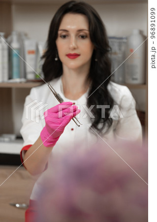 Uno spoons in the hands of a cosmetologist, tools of a cosmetologist for cleaning the face. Uno spoons in the hands of a cosmetologist, tools of a cosmetologist for cleaning the face. 96891099