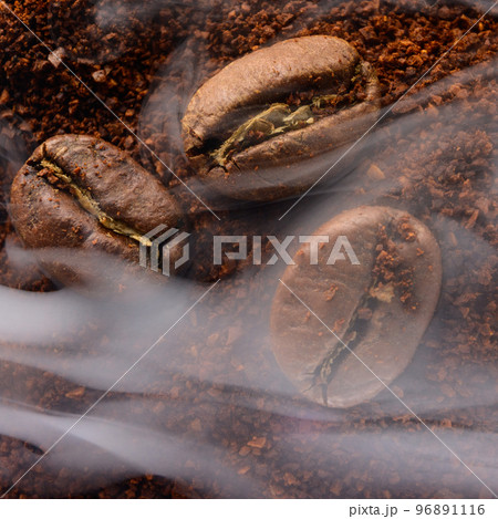 top view of coffee beans and ground coffee steaming with heat. 96891116