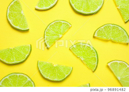 Juicy fresh lime slices on yellow background, flat lay 96891482
