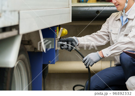 車の充電をする整備士 96892332