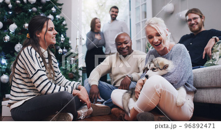 Christmas, dog and party with friends in living room for celebration, relax and festive. Happy, holiday and xmas with pet and group of people at home for gathering, reunion and social event together Christmas, dog and party with friends in living room for celebration, relax and festive. Happy, holiday and xmas with pet and group of people at home for gathering, reunion and social event together 96892471