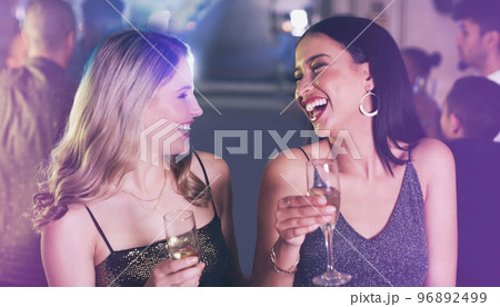 Friends, drinks and party at nightclub to celebrate champagne glass, happiness and new years or birthday energy with funny conversation. Girls at club, event or disco for happy hour celebration 96892499