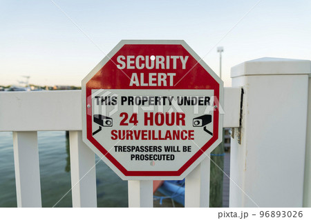 Security Alert This Property Under 24 Hour Surveillance sign on a railings at Destin, Florida 96893026
