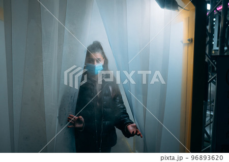 Woman at medic mask is staying in a disinfection tunnel Woman at medic mask is staying in a disinfection tunnel 96893620