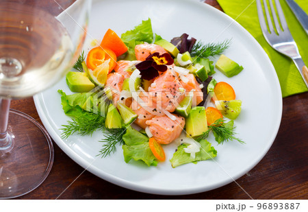 Ceviche from salmon on plate with cumquat, green dill and avocado 96893887