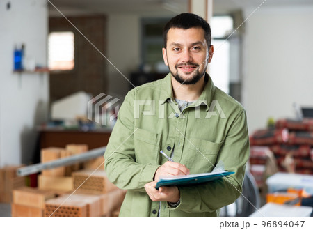 Engineer makes notes, holding a folder with documents Engineer makes notes, holding a folder with documents 96894047