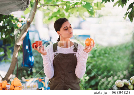 Young saleswoman holding home-grown tomatos in hands 96894823