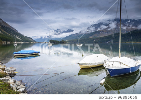 Sailboat anchored on Silvaplana Lake at misty dawn, Swiss Alps, Switzerland 96895059