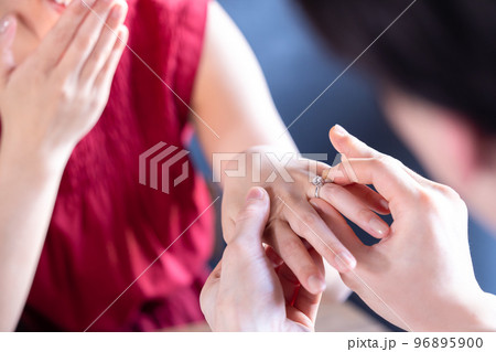 プロポーズ　薬指に指輪をはめてもらう女性 96895900